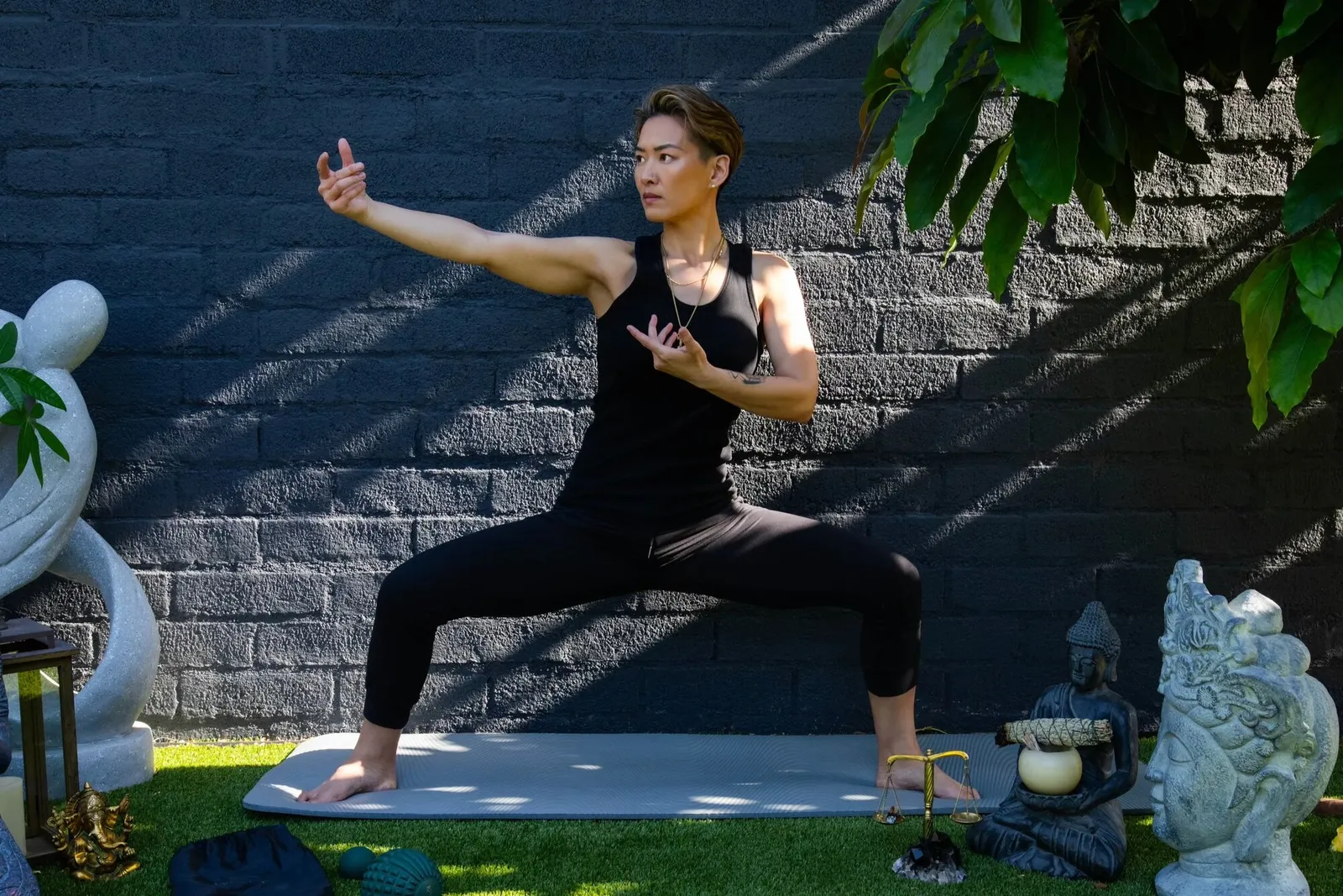 Angie Wong moving through a tai chi form in the garden